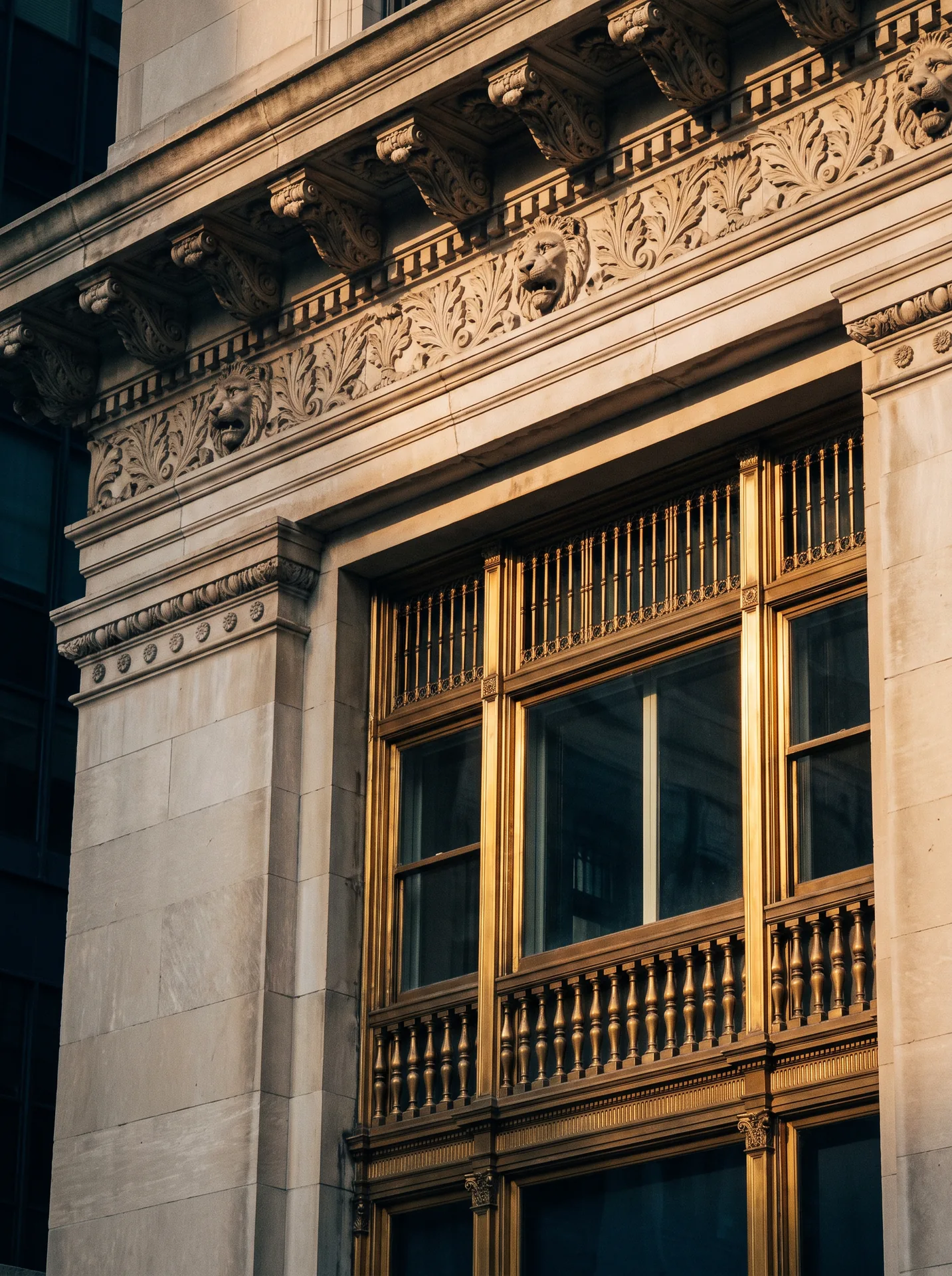 Detail of a brass-trimmed New York City building facade at golden hour